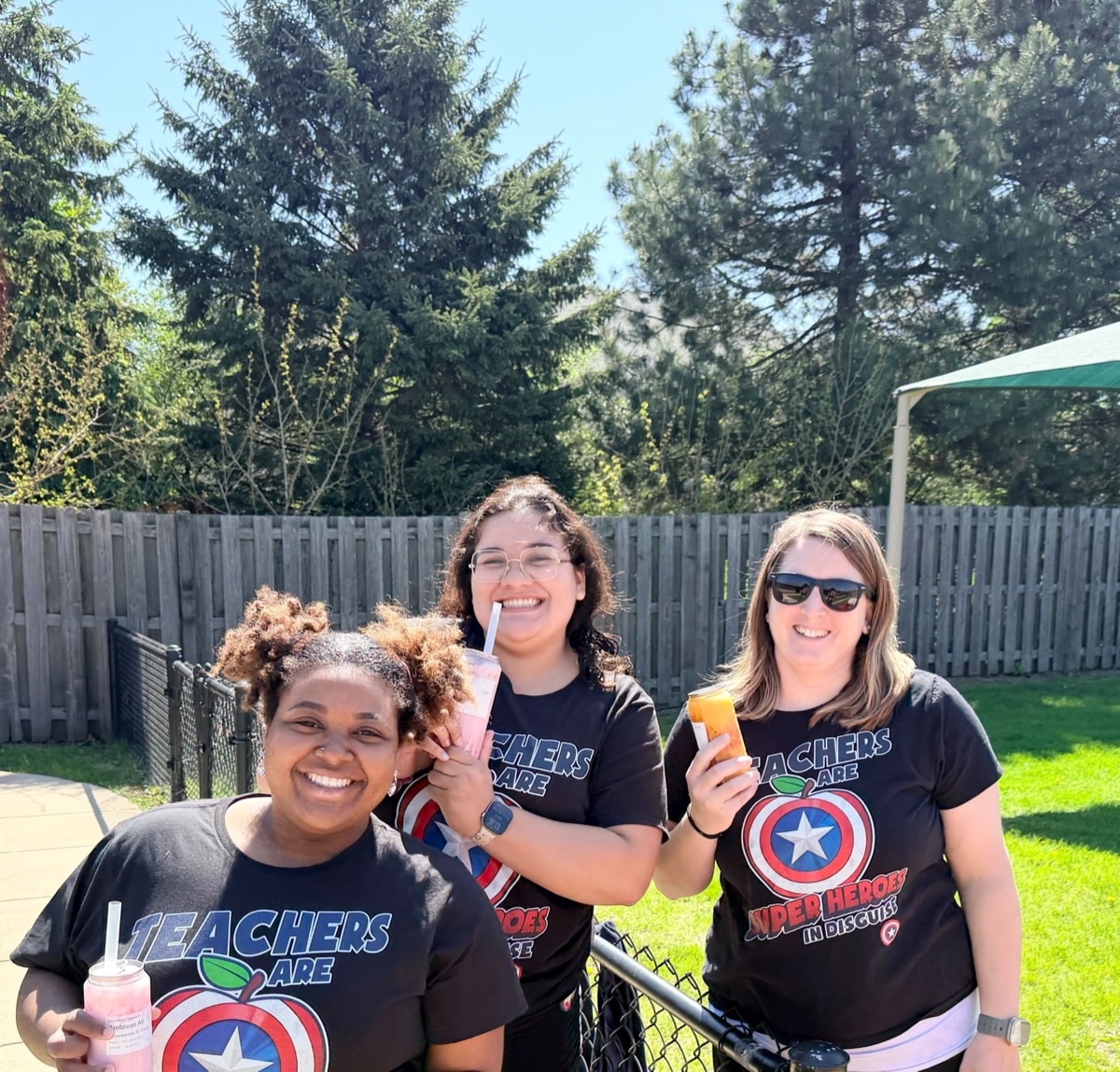 Teachers outside with smoothies, smiling in the sun